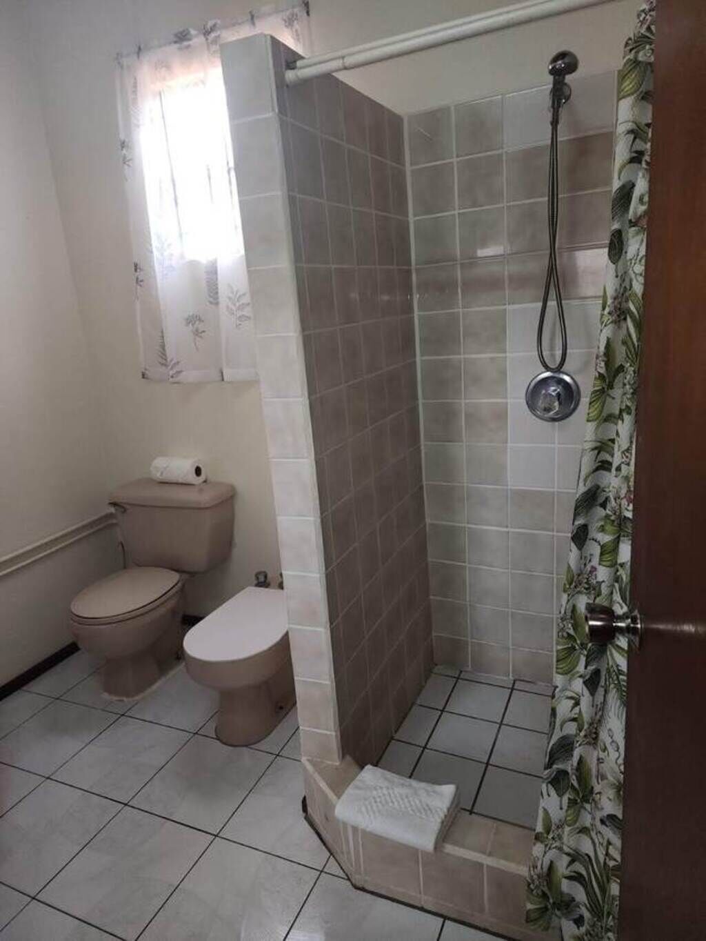 Ein Badezimmer mit Toilette, Bidet und Duschbereich.