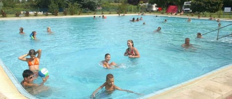 A swimming pool with people enjoying the water.