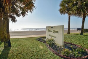 A sign for Ocean Grove with a view of the beach and palm trees. - Ocean Grove 704-Ocean View by Ryson Vacation Rentals (Galveston)