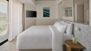 A modern hotel room with a large bed, a flat-screen TV, a painting, and a view of the outdoors. - Ardo (Townsville)