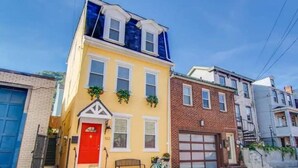 A yellow two-story building with a red door and a bicycle parked outside. - South Side Bicycle Home Sleeps 6 (Pittsburgh)