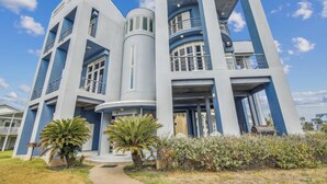 A modern building with a unique architectural design, featuring multiple levels and balconies. - Pirates' Castle by Ryson Vacation Rentals (Galveston)