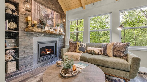 A cozy living room with a fireplace, a sofa with decorative pillows, and a coffee table with a plant.
