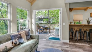 A cozy living room with a sofa, a dining table, and a kitchen area with bar stools.
