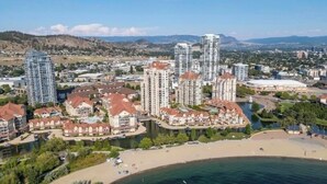 A coastal residential area with high-rise buildings, a beach, and a river. - Sunset Waterfont Resort 12. Luxury Lakeside, Lakeview 3 bed/2bath Kelowna Condo. (Kelowna)