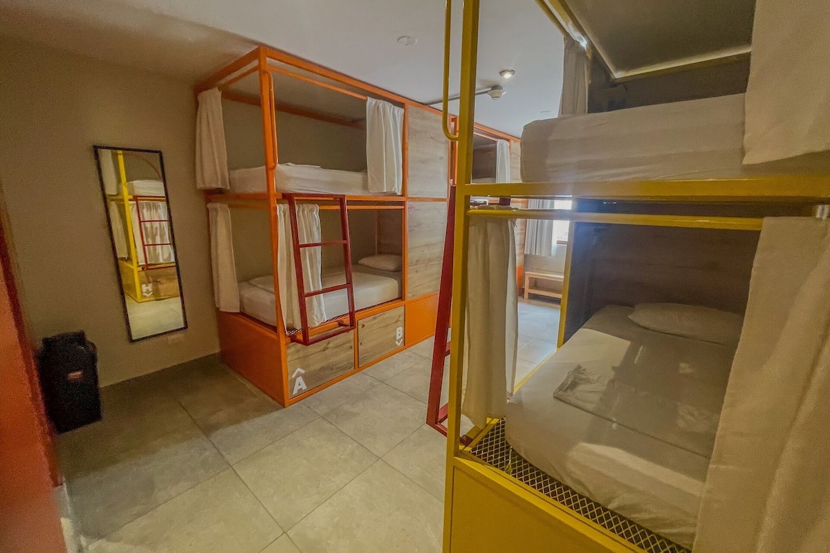 A room with bunk beds, a mirror, and a window.