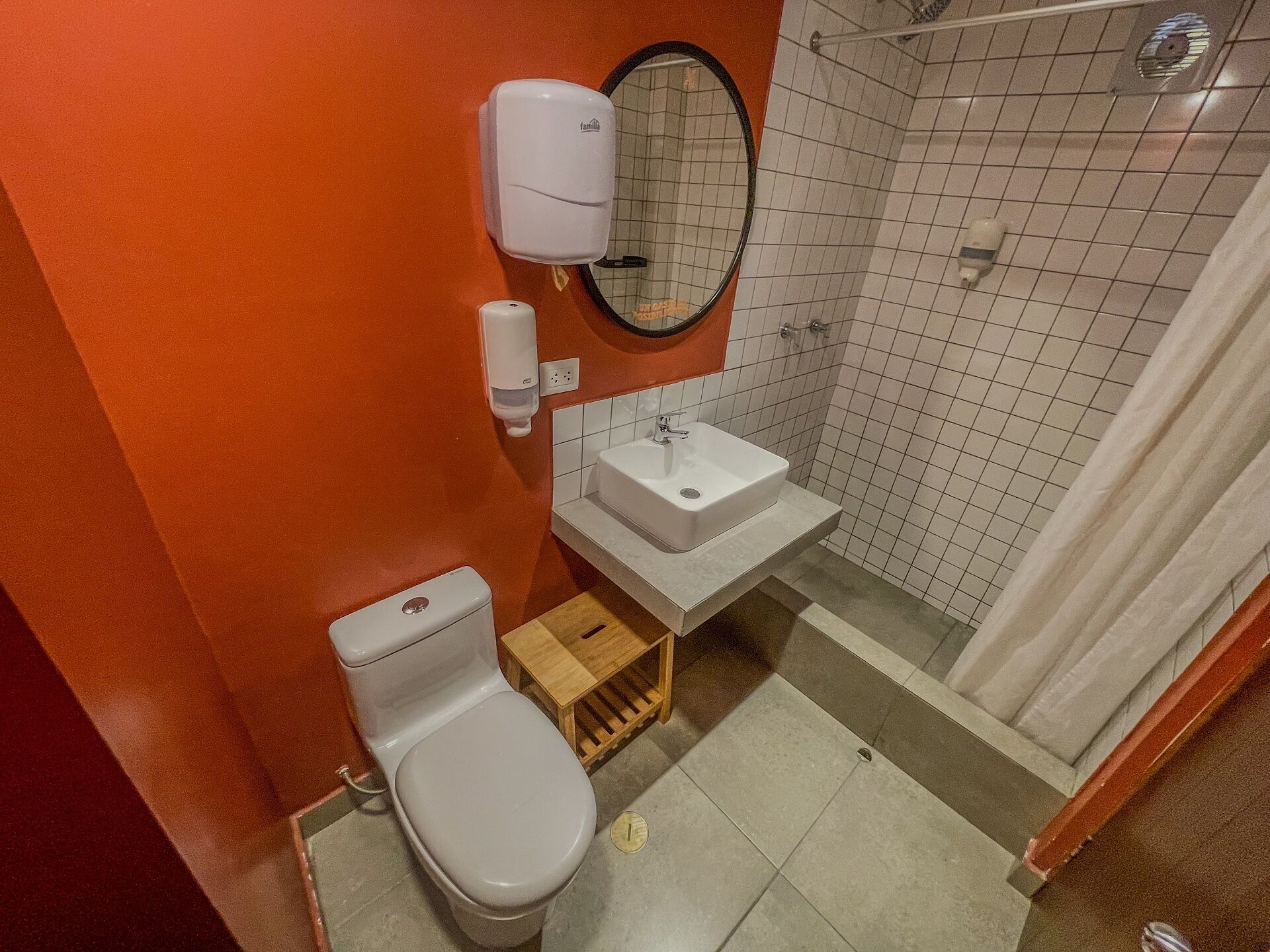 A small bathroom with a toilet, sink, and shower.