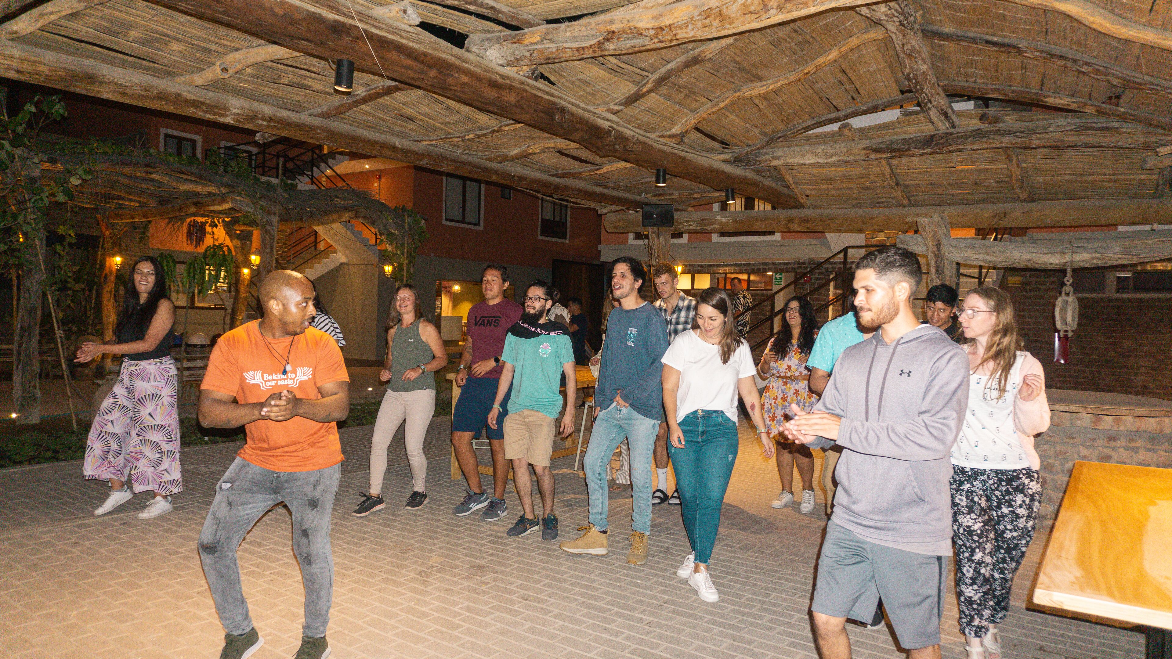 A group of people in an outdoor area with a rustic wooden ceiling and brick walls.