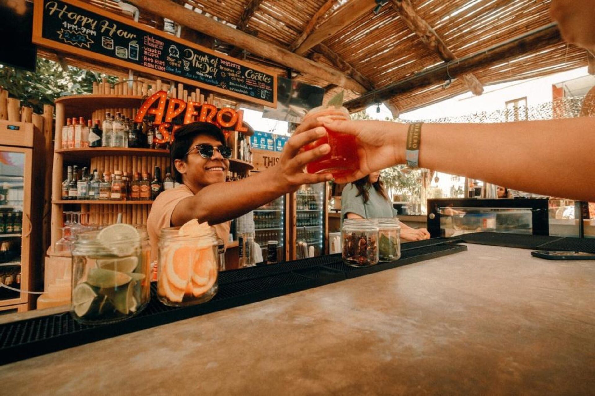 A bar with a rustic wooden interior, shelves stocked with bottles, and a chalkboard menu.