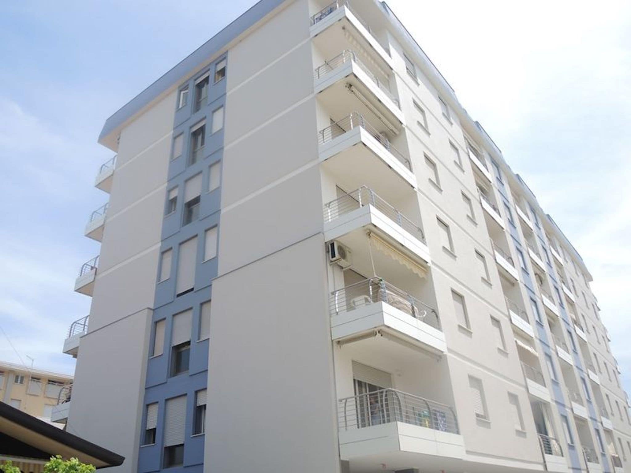 Un edificio residenziale a più piani con balconi e facciata lineare.