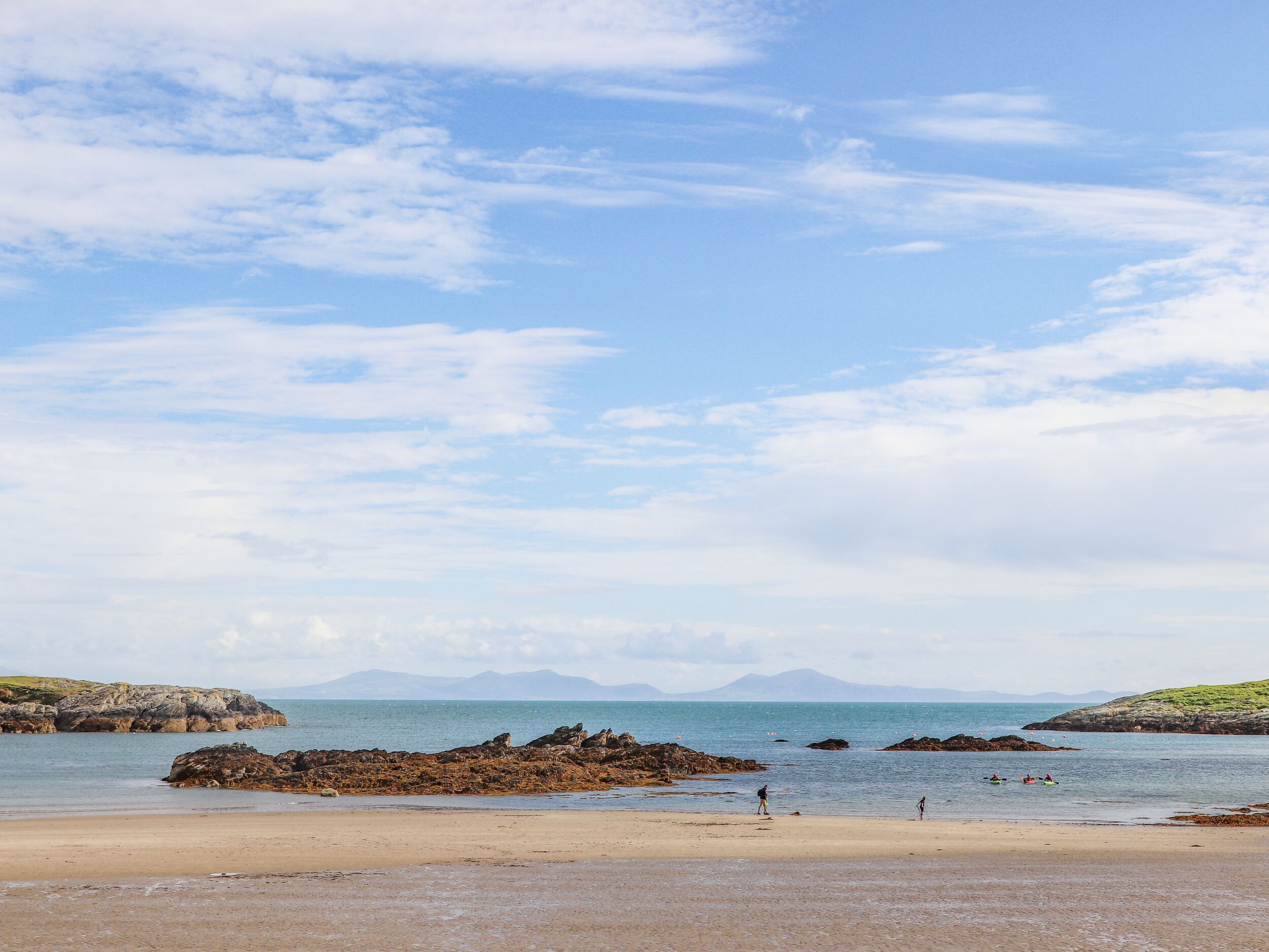 Ein Strand mit Felsen und ruhigem Wasser.