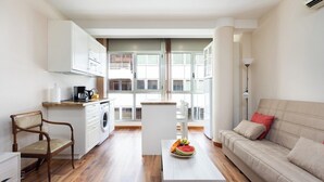 A modern apartment with a kitchen, dining area, and living room.