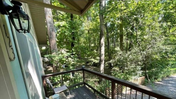 A wooden deck with a railing, a bench, and a table. - Hidden Cottage Wooded Escape 2 bed/1 bath (Johnson City)