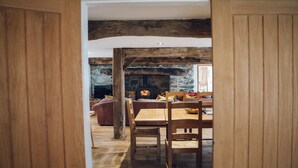 A rustic interior with a stone fireplace, wooden furniture, and exposed wooden beams.