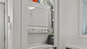A modern kitchen with a built-in refrigerator, a dishwasher, and a dark wooden cabinet.