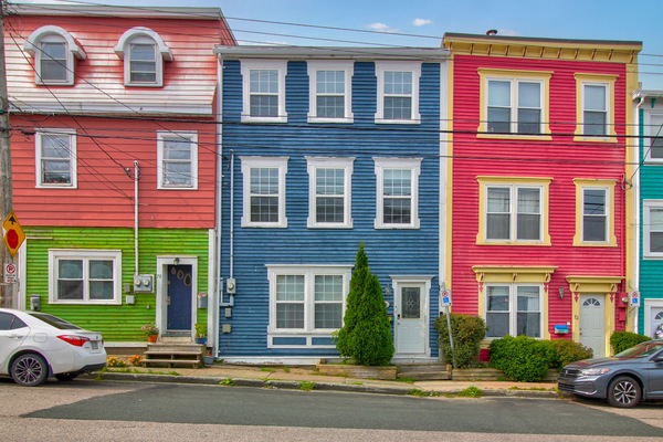 The houses are lined up in a row, with a cohesive architectural style that creates a harmonious look along the street. The pristine street features clean sidewalks, well-maintained roads, and ample parking spaces along the curb, creating a tidy, organized atmosphere with well-kept houses that offer a welcoming, peaceful environment for residents and visitors.