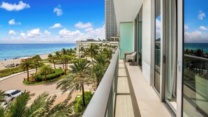 A balcony with a view of the beach and ocean, a modern building, and a clear sky. - ★★★★★ Stylish Retreat at Lyfe Resort Steps Away from the Ocean with Rooftop Pool (Hollywood)