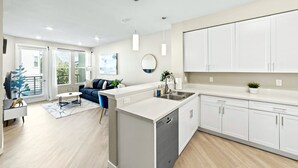 A modern kitchen with white cabinets, a dishwasher, and a countertop. - Designer Apt With Jacuzzi Sky Lounge Gym Access (Sparks)