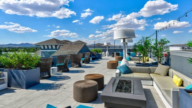 A rooftop terrace with outdoor seating, a fire pit, and a view of the mountains. - Designer Apt With Jacuzzi Sky Lounge Gym Access (Sparks)