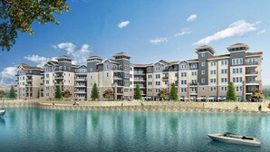 A multi-story hotel with a waterfront view, featuring balconies and a stone facade. - Designer Apt With Jacuzzi Sky Lounge Gym Access (Sparks)