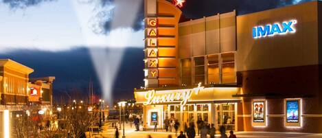 A cinema complex with a prominent IMAX sign and a marquee advertising a 'Luxury' theater.