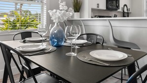 A dining table set with plates, cutlery, and a vase with flowers. - Relaxing 2BR Florida Home Close to Beach (Osprey)