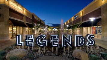 A commercial area with illuminated storefronts and a prominent 'LEGENDS' sign.