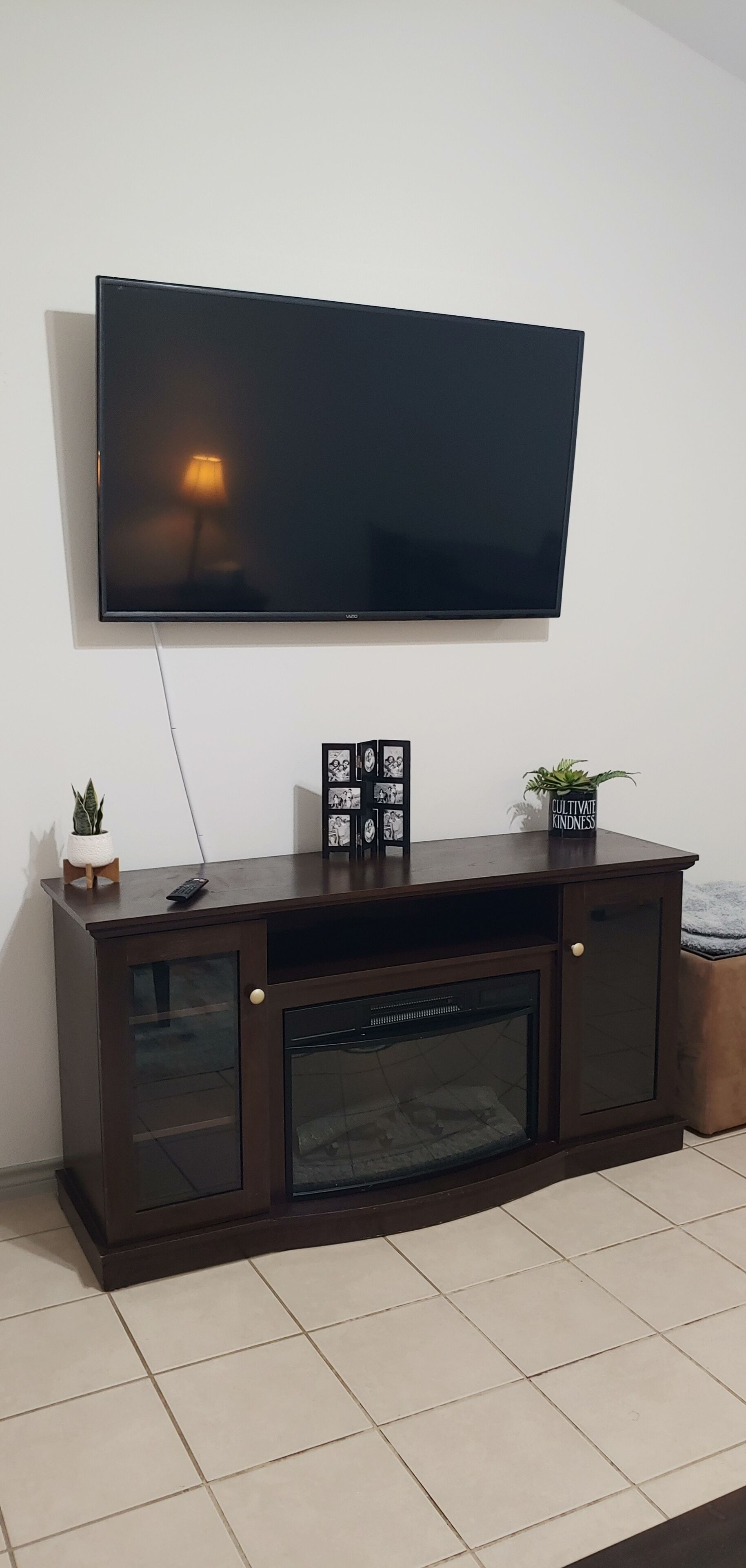 A dark wooden entertainment center with a flat-screen TV mounted above it.