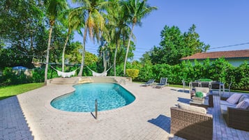 Alberca al aire libre, sombrillas en la alberca y camastros