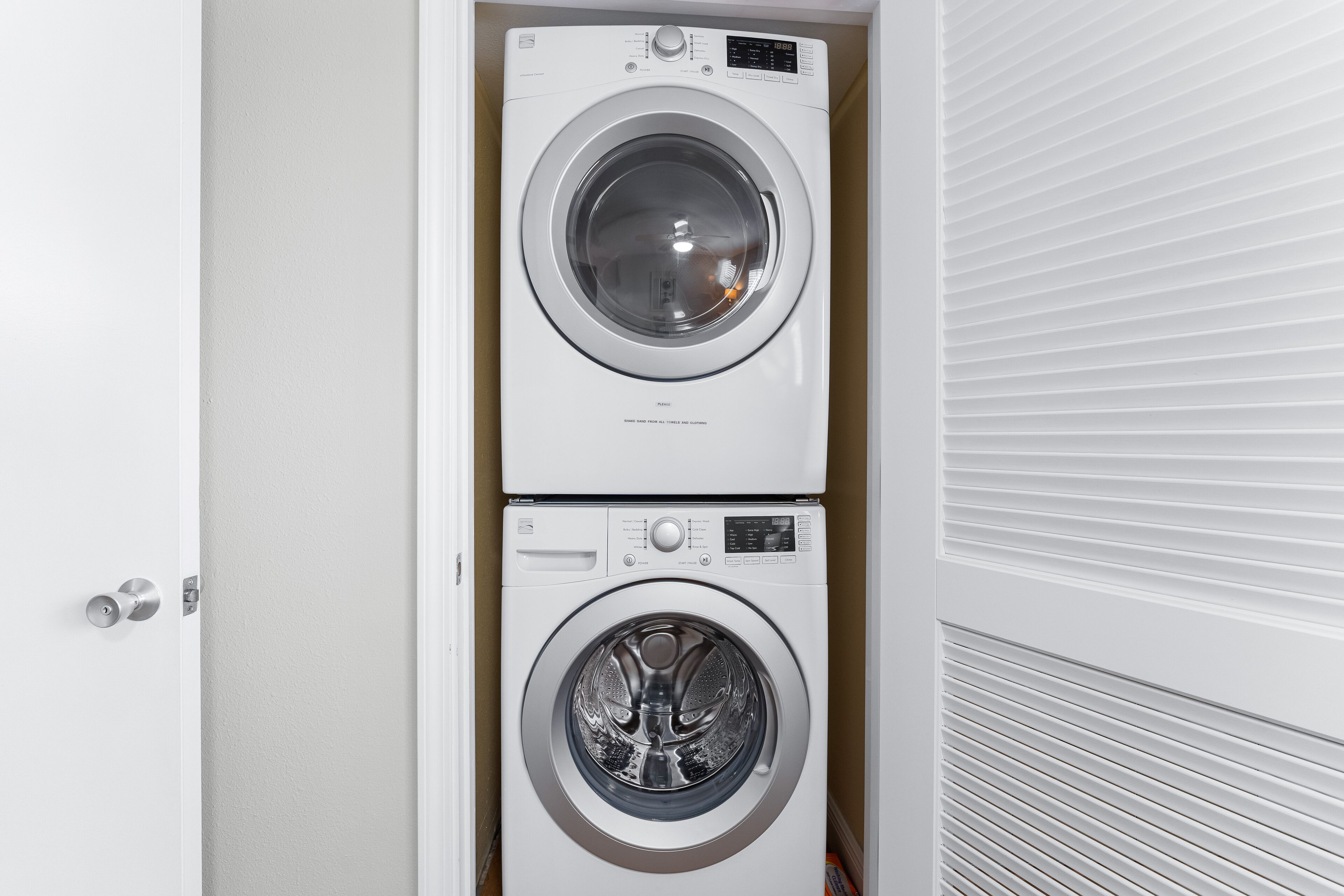 A compact, two-door laundry room with a modern design, featuring a built-in washer and dryer.