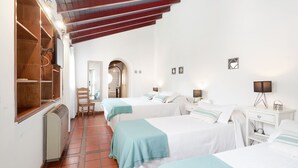 A hotel room with two beds, a wooden wardrobe, a chair, and a small table with a lamp. - Posada del huerto by Vilvey Turismo (Chacras de Coria)