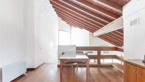 A spacious room with a wooden floor, a glass table, and a high ceiling with exposed beams. - Posada del huerto by Vilvey Turismo (Chacras de Coria)