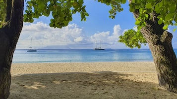 Na praia, areia branca, espreguiçadeiras, toalhas de praia