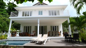A two-story house with a balcony, a pool, and outdoor furniture. - Las Brísas Villa - Chateau Elysium (Mahé Island)