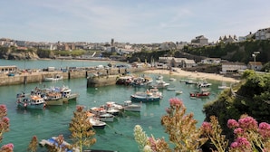 Eine Küstenstadt mit einem Hafen voller Boote, einem Sandstrand und Wohngebäuden.
