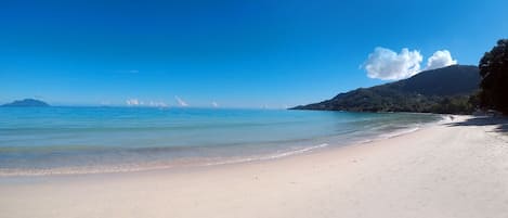 On the beach, white sand, sun-loungers, beach towels