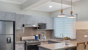 Una cocina moderna con encimeras de granito, electrodomésticos de acero inoxidable y una isla integrada con asientos.