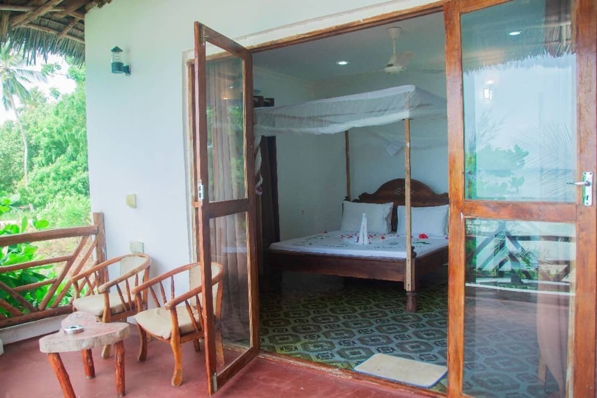 A room with a bed, a chair, and a small table.