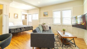 A cozy room with a bed, sofa, and a TV.