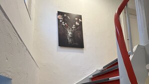 Escadaria com degraus vermelhos e corrimão preto.