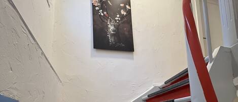 A staircase with red steps and a black handrail.