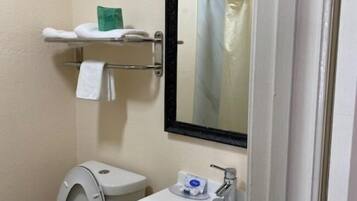 Ein kleines Badezimmer mit Toilette, Waschbecken und Spiegel.