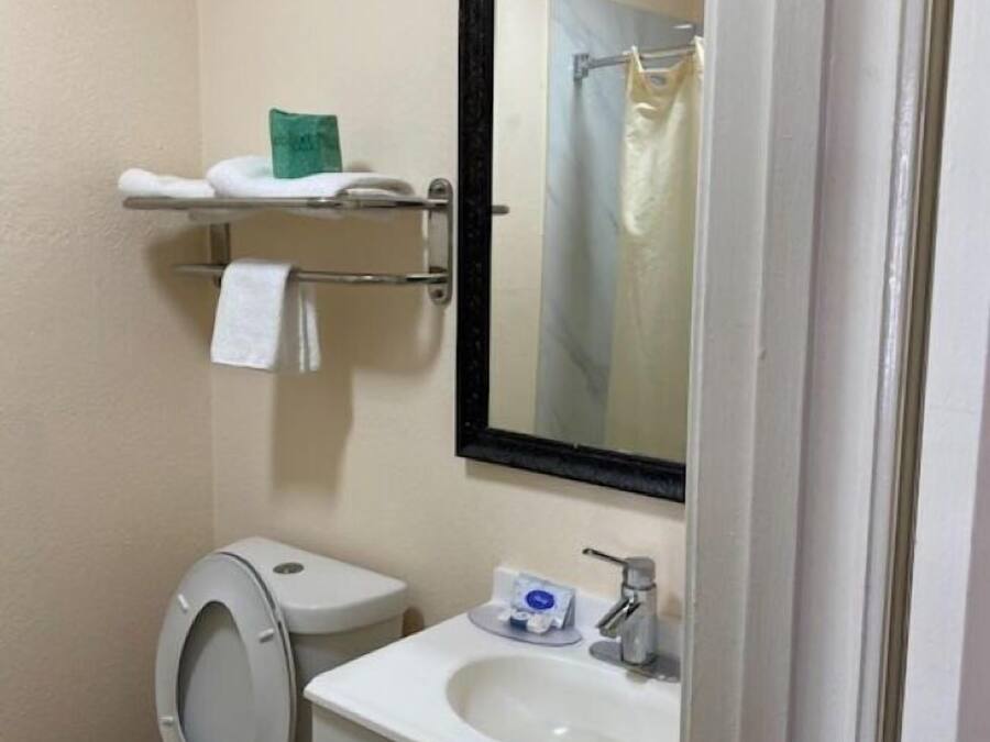 Ein kleines Badezimmer mit Toilette, Waschbecken und Spiegel.