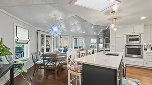 Een moderne keuken met witte kasten, roestvrijstalen apparatuur en een groot eiland.