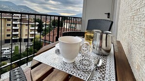 A balcony with a table set for two, featuring a white bowl, a glass, and a metal container. - LAKEHOUSE ENJOY (Pallanza)