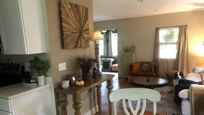 A living room with a sofa, a coffee table, and a dining area with a table and chairs.