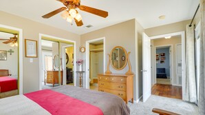Une chambre à coucher avec un lit, une commode et un ventilateur de plafond.