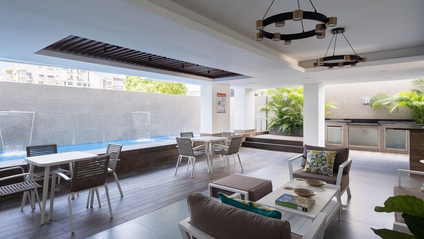 A modern outdoor patio area with a pool, seating, and a view of the city. - City Center Piantini W/ Pool, WiFi By YellowKey (Santo Domingo)