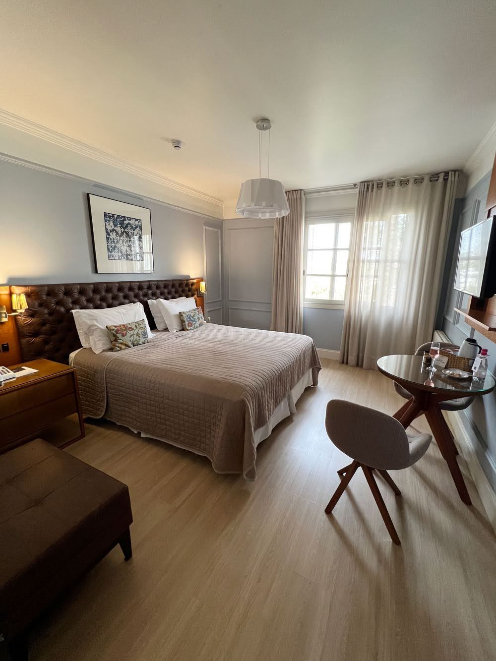 Une chambre d’hôtel avec un grand lit, des tables de chevet, un bureau et une chaise.