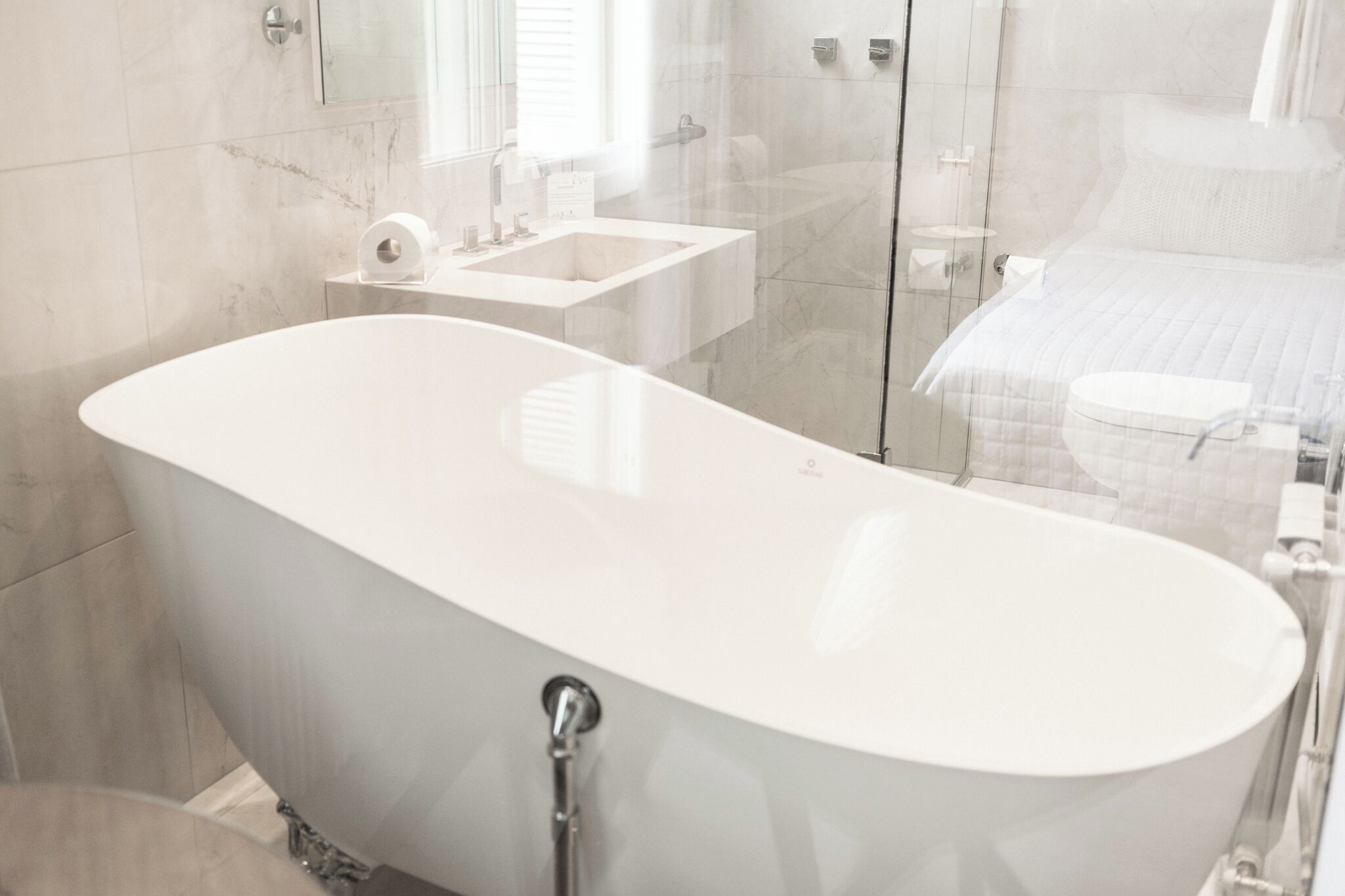 Un baño moderno con una bañera independiente, cabina de ducha de cristal y zona de aseo separada.